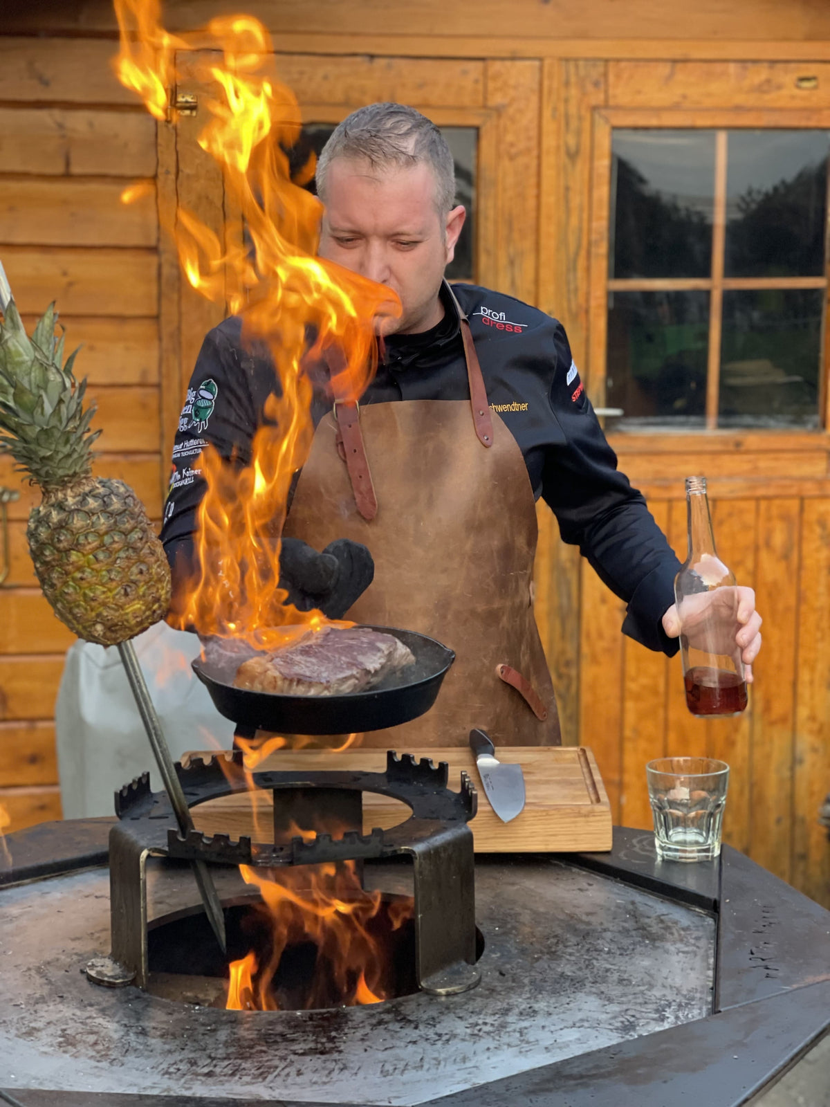 Jürgen Gschwendtner beim Live-Cooking mit offener Flamme und Fleischgericht am Grill