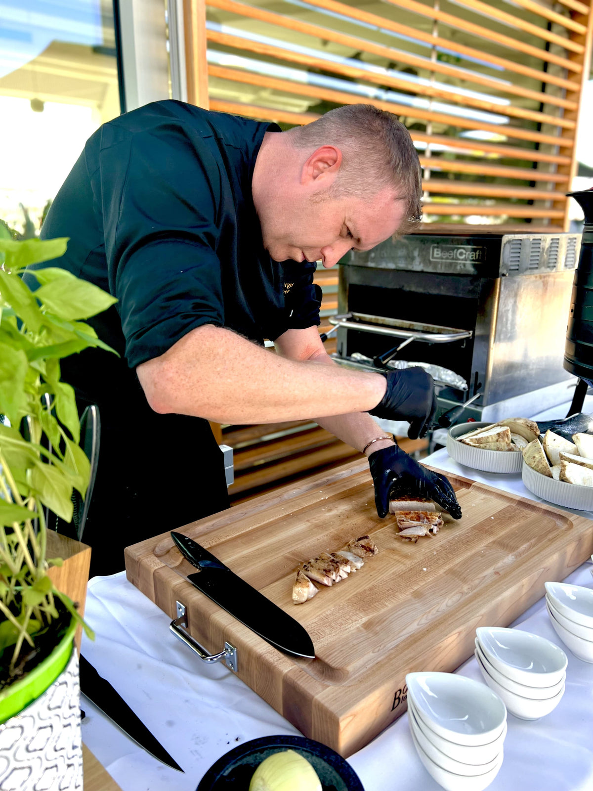Jürgen Gschwendtner beim Kochen über offenem Feuer mit Pfanne und Live-Cooking-Setup im Freien
